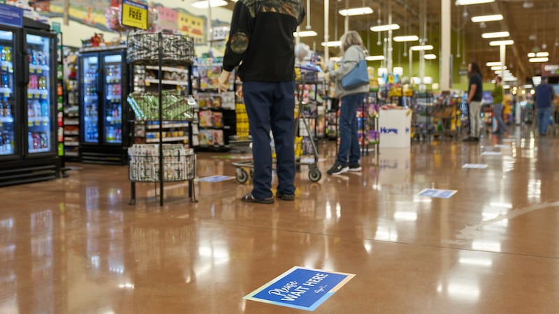 Credit: Kroger grocery store. Signs laid out to display where customers can stand for social...