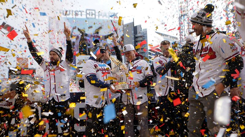 FILE - Atlanta Braves manager Brian Snitker holds the Commissioner's Trophy during a...