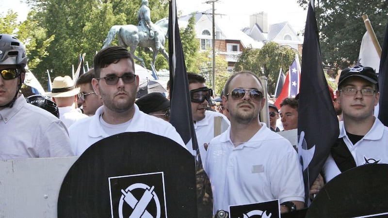 In this Saturday, Aug. 12, 2017 photo, James Alex Fields Jr., second from left, holds a black...