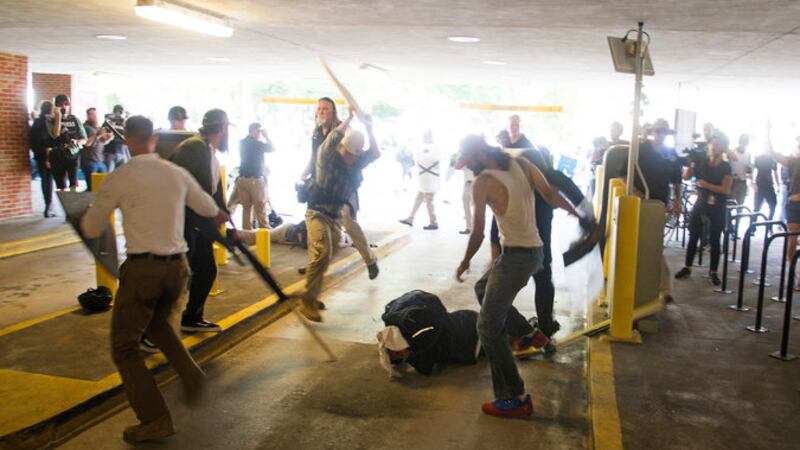 In this Saturday, Aug. 12, 2017 photo, DeAndre Harris, bottom is assaulted in a parking garage...