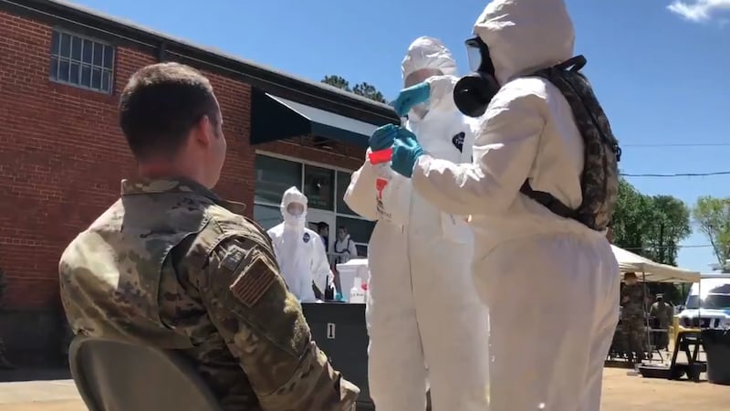 MSgt. Stephen Legge, with the Virginia National Guard, gets swabbed for COVID-19 as part of...